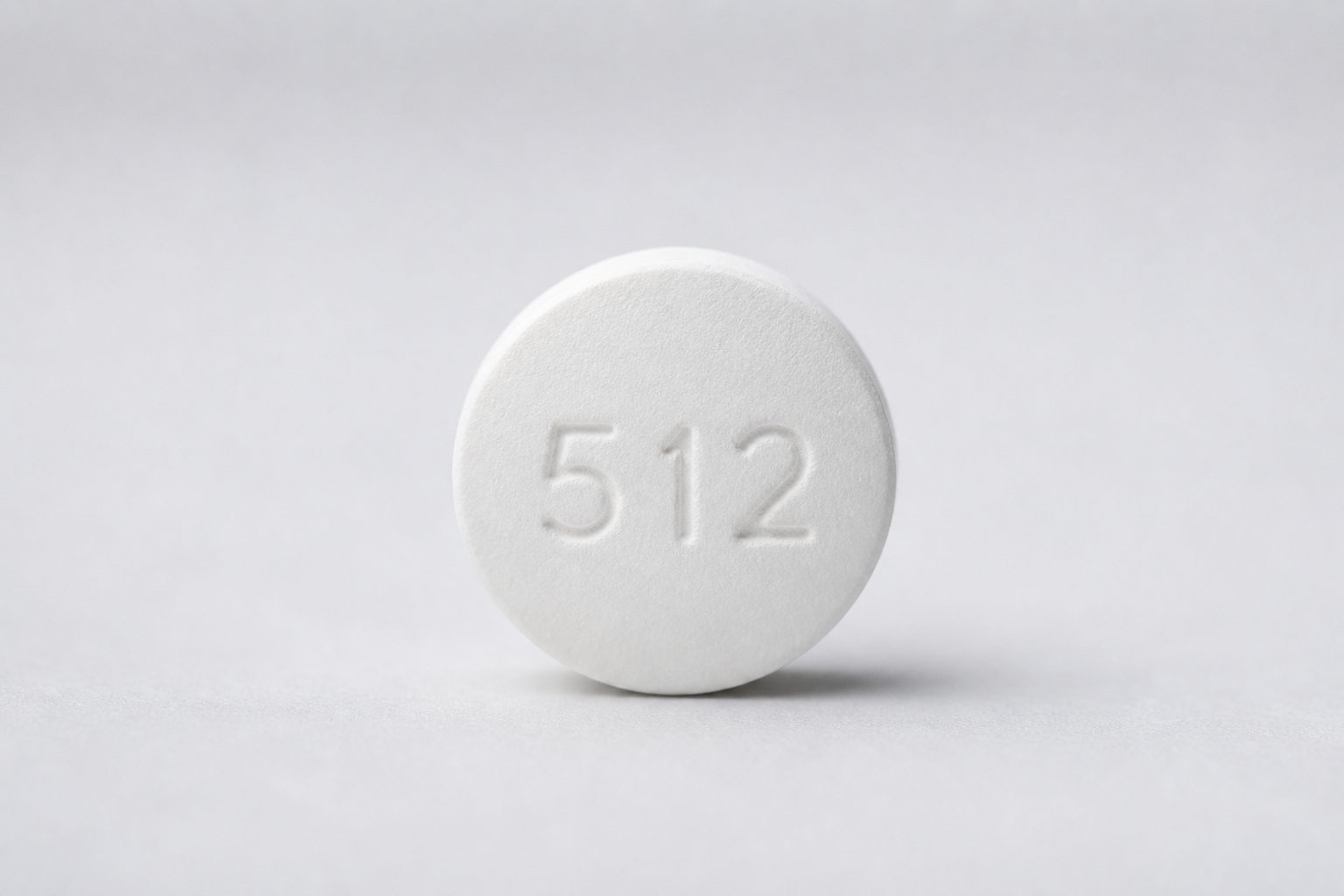 Close-up of a round white tablet with imprint 512, used to illustrate the Pill Identifier API.
